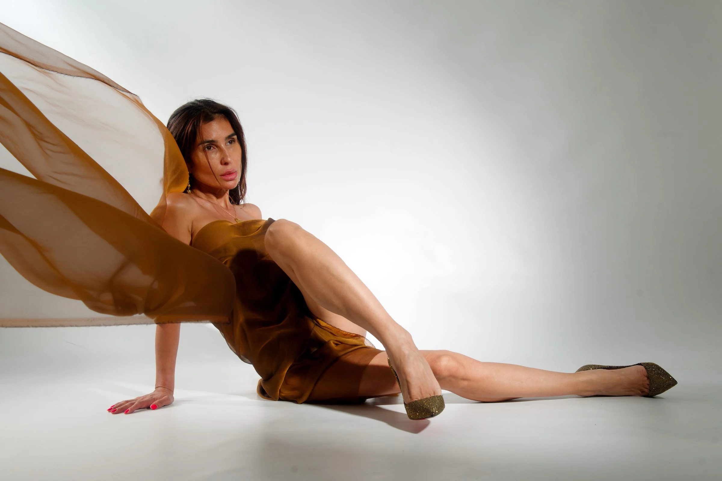 Goddess Oksana reclining, a bronze silk veil in motion
