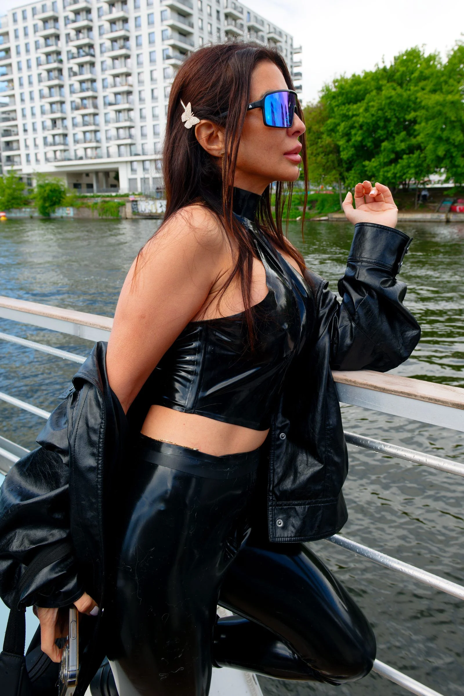 Goddess Oksana by the water, a black jacket over her shoulder